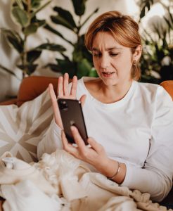 Persoană care comunică în limbaj mimico-gestual într-un apel video pe telefon.